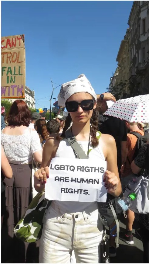 Vita holding a sign reading LGBTQ rights are human rights at a march
